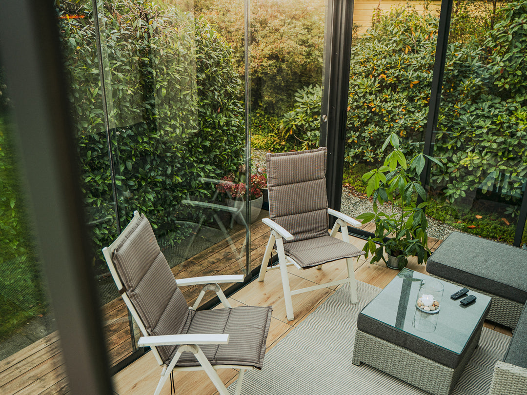 Pergolux Crystal Conservatory umgeben von Pflanzen im Garten. Gemütliche, frische Begegnung mit der Natur.